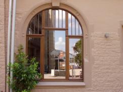 Holzfenster mit Rundbogen und Sprossen